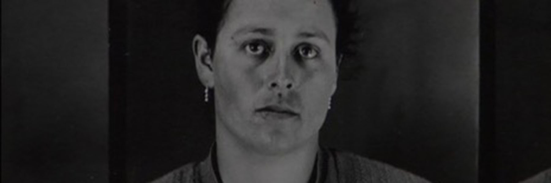 A black-and-white image of a lady staring at the camera.